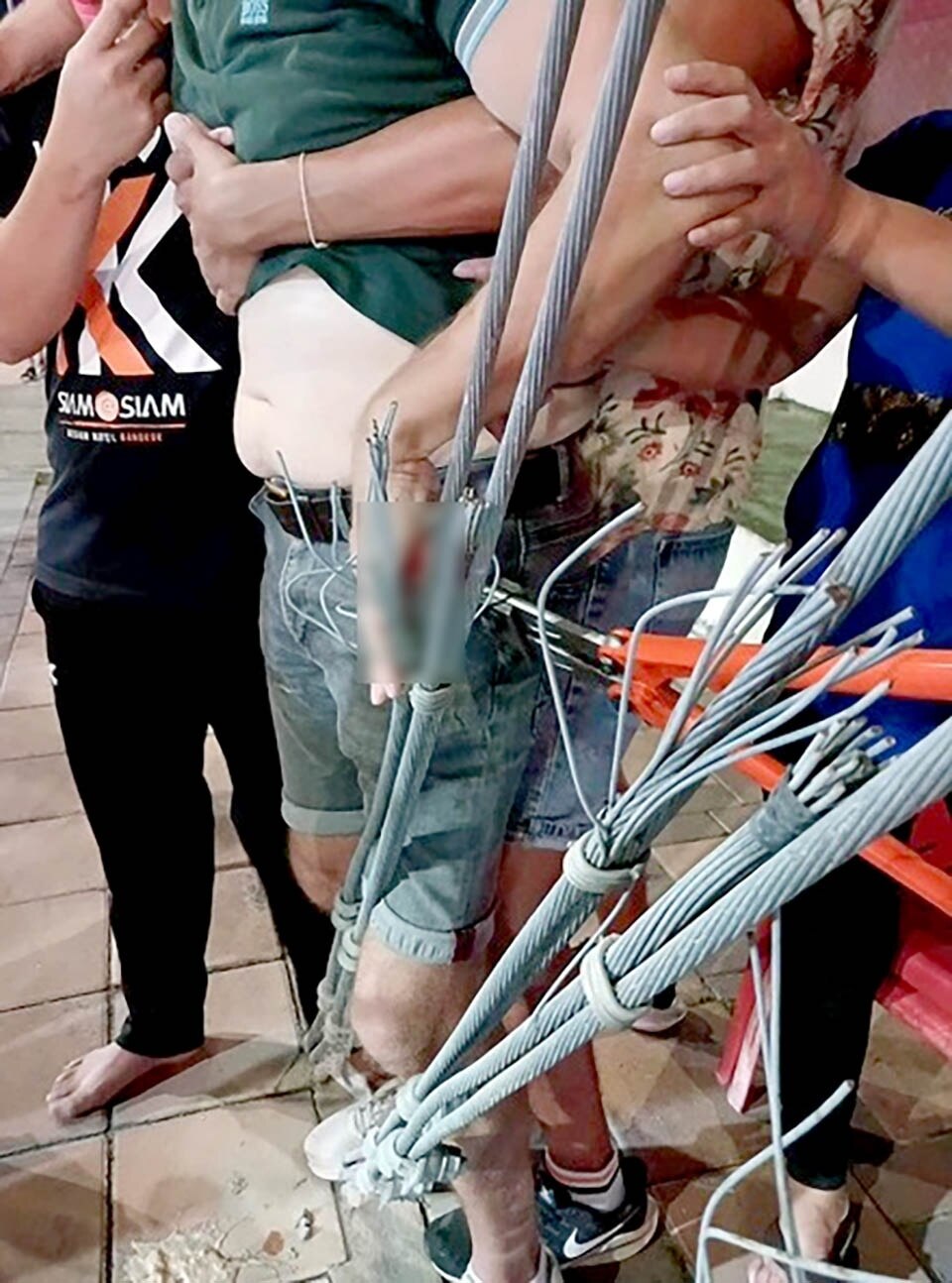 Ausländer stolpert, Hand von Drahtseil in Pattaya aufgespießt