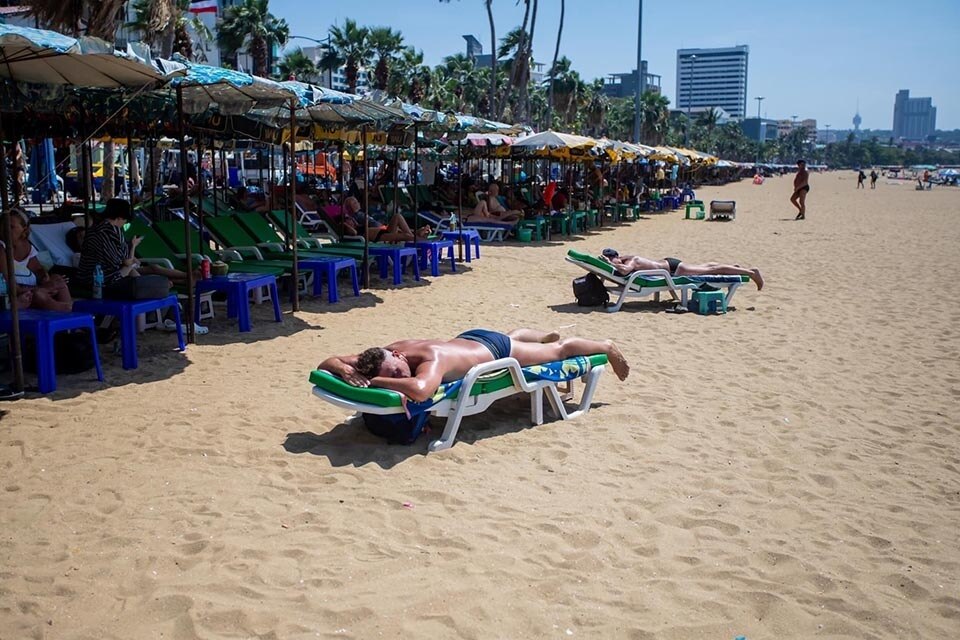 Ausländische Besucher lassen sich von steigenden Temperaturen nicht beirren und genießen das Sonnenbad in Pattaya