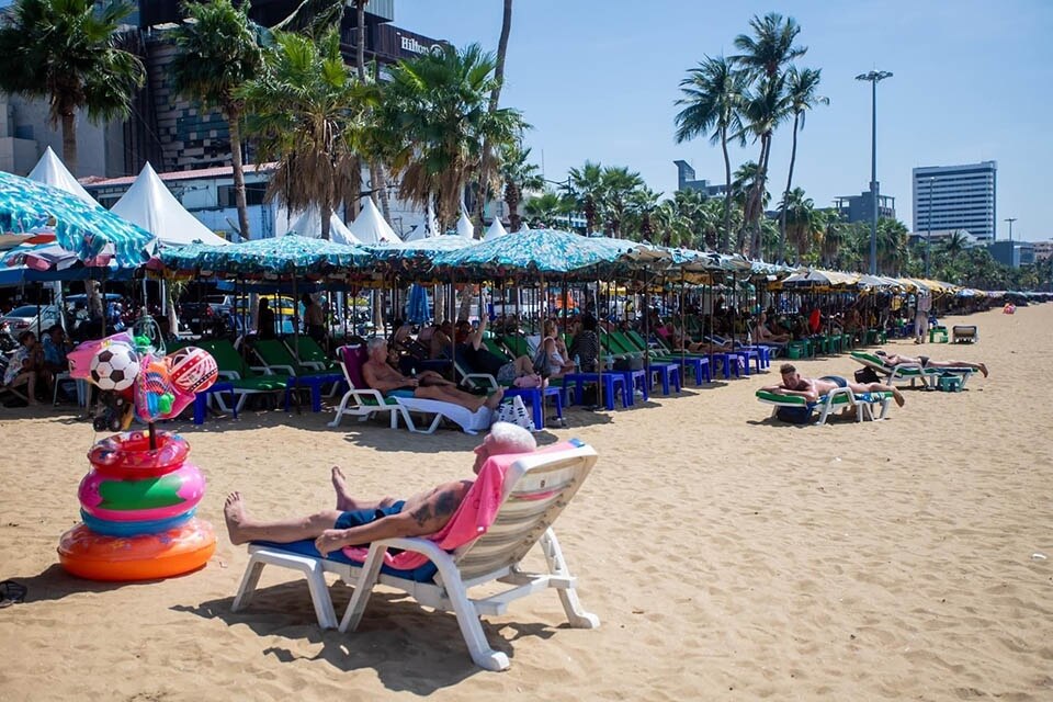 Ausländische Besucher lassen sich von steigenden Temperaturen nicht beirren und genießen das Sonnenbad in Pattaya