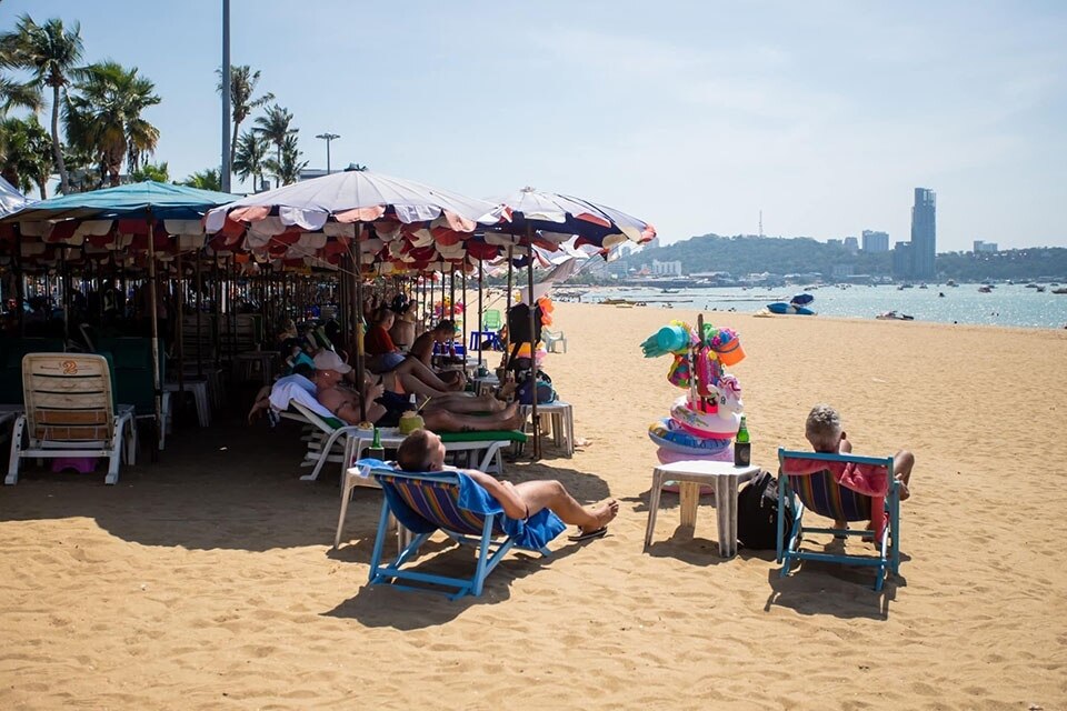 Ausländische Besucher lassen sich von steigenden Temperaturen nicht beirren und genießen das Sonnenbad in Pattaya