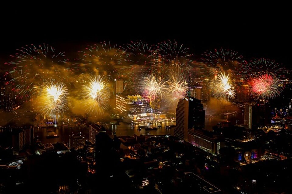 Touristen in Bangkok genießen spektakuläres Feuerwerk am Chao Phraya Fluss