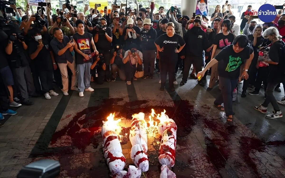 Demonstranten verbrennen vor dem hauptquartier der pheu thai bildnisse