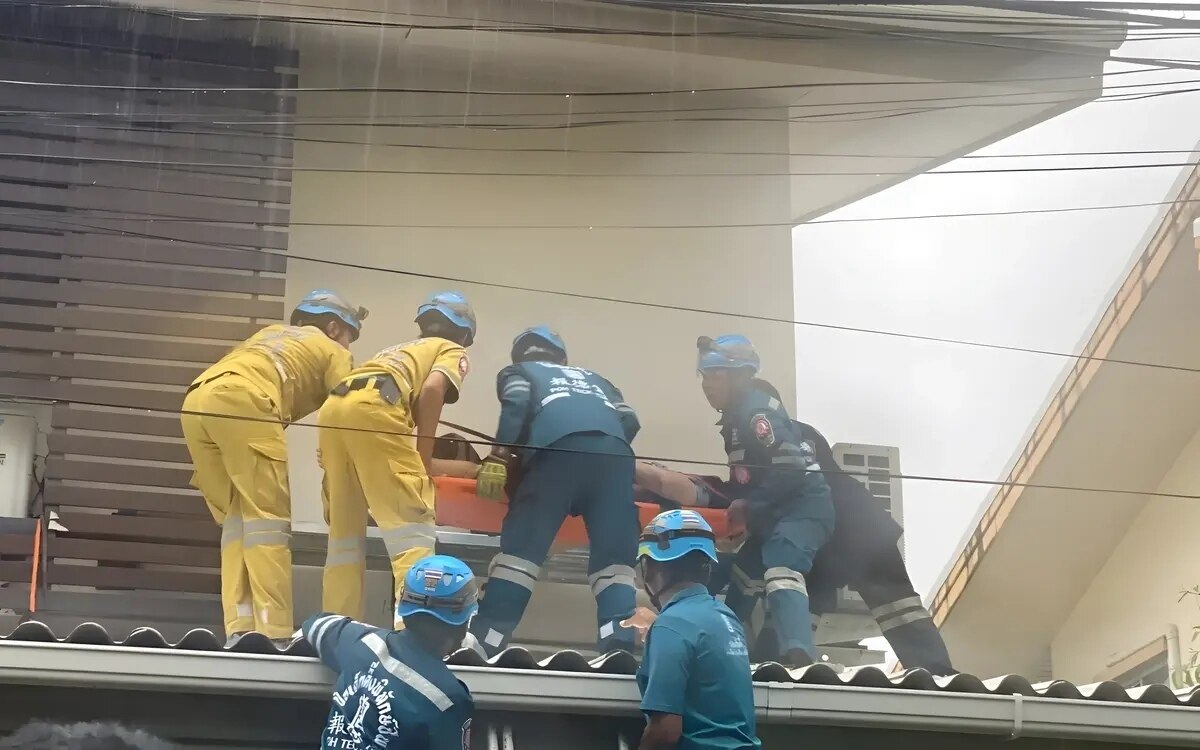 Rettungskraefte kaempfen im regen um das leben eines durch stromschlag bewusstlosen mannes in samut